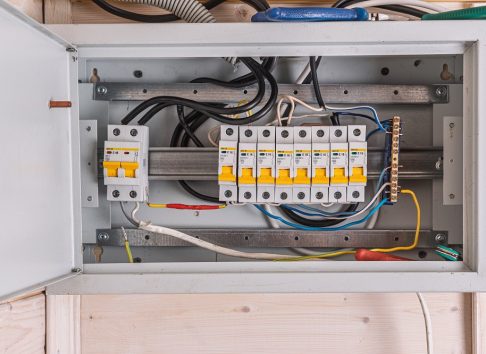 Open electrical panel with neatly arranged circuit breakers and colorful wires highlights organized wiring and safety in home power distribution.